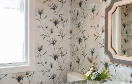 Neutral floral wallpaper & dark marble countertop bathroom