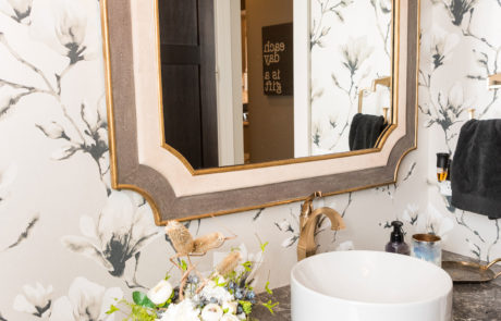 Neutral floral wallpaper & dark marble countertop bathroom