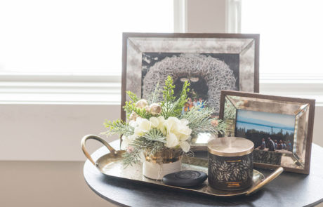 Coffee table with picture frames, florals, and scented candle